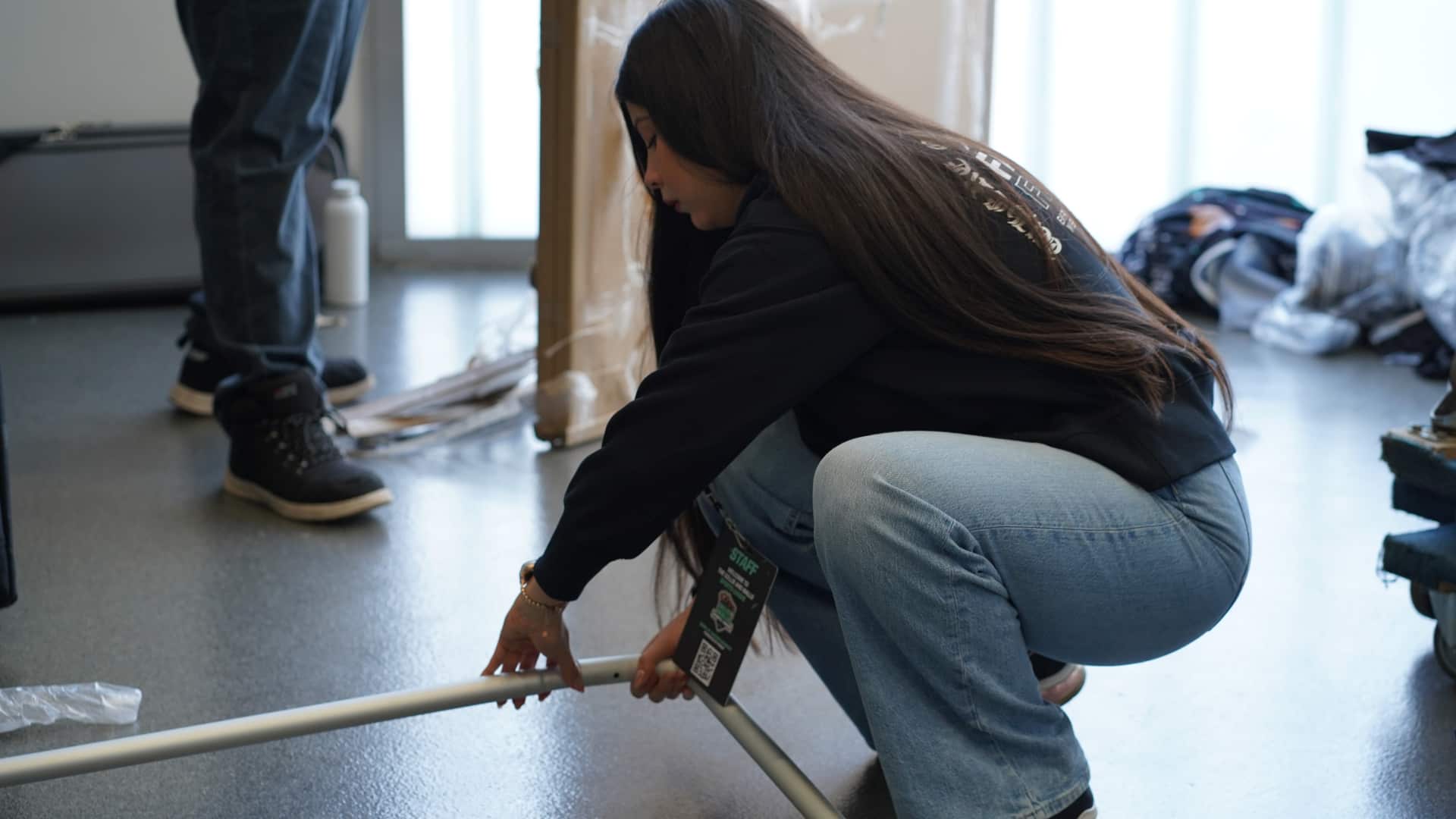 Event staff member assembling activation setup equipment on-site in Denver, preparing branded display structure before event launch.